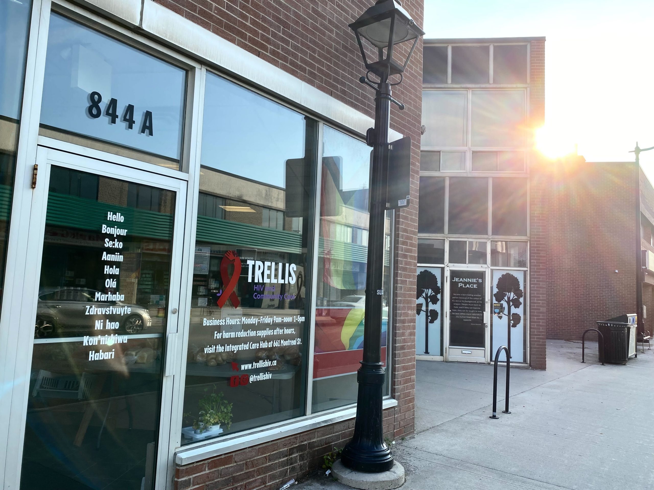 Image of 844a Princess Street. The building has lots of windows, with greeting signage that says "welcome" in several languages. The sun in setting in the background.